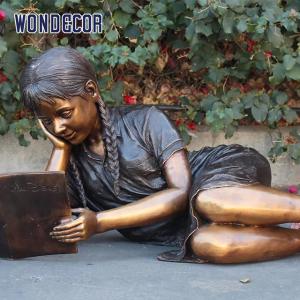 China Customized garden decoration, life-size bronze statue of a girl lying on her side reading a book wholesale