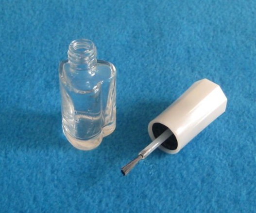 Empty glass nail polish bottle with cap and brush
